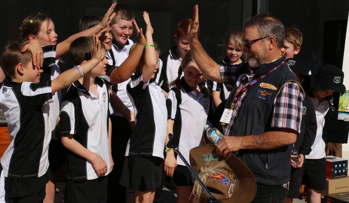 HIGH FIVE: Legendary Australian singer John Williamson with Ellerston Public School students after they sang 'True Blue' to the Variety Bashers on Sunday.