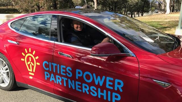 DRIVING CHANGE: Upper Hunter Shire councillor Kiwa Fisher powers up an electric car at the Cities Power Partnership launch in Canberra.