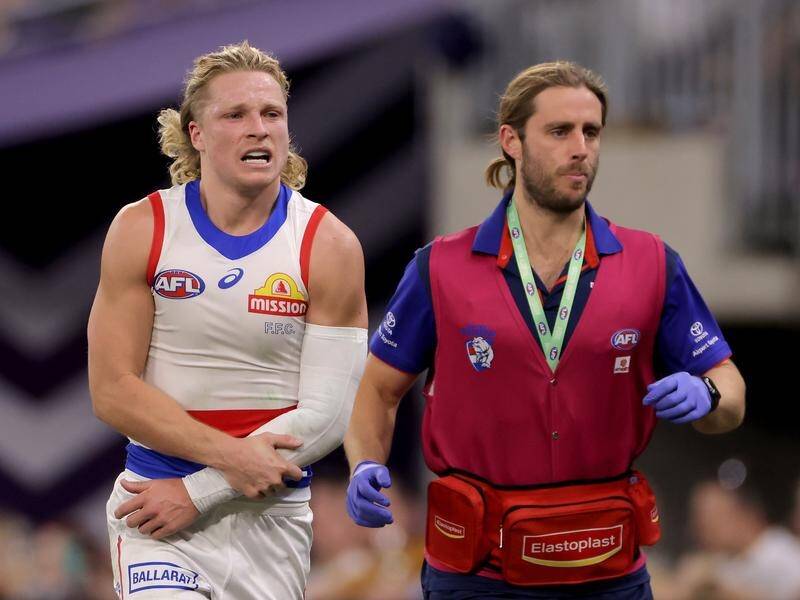 Bulldogs' "tough bugger" Cody Weightman leaving the field injured during the Dockers match. (Richard Wainwright/AAP PHOTOS)