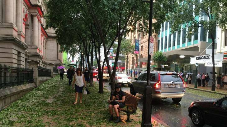 CBD workers begin to venture out onto George Street after the storm. Photo: Amy Remeikis