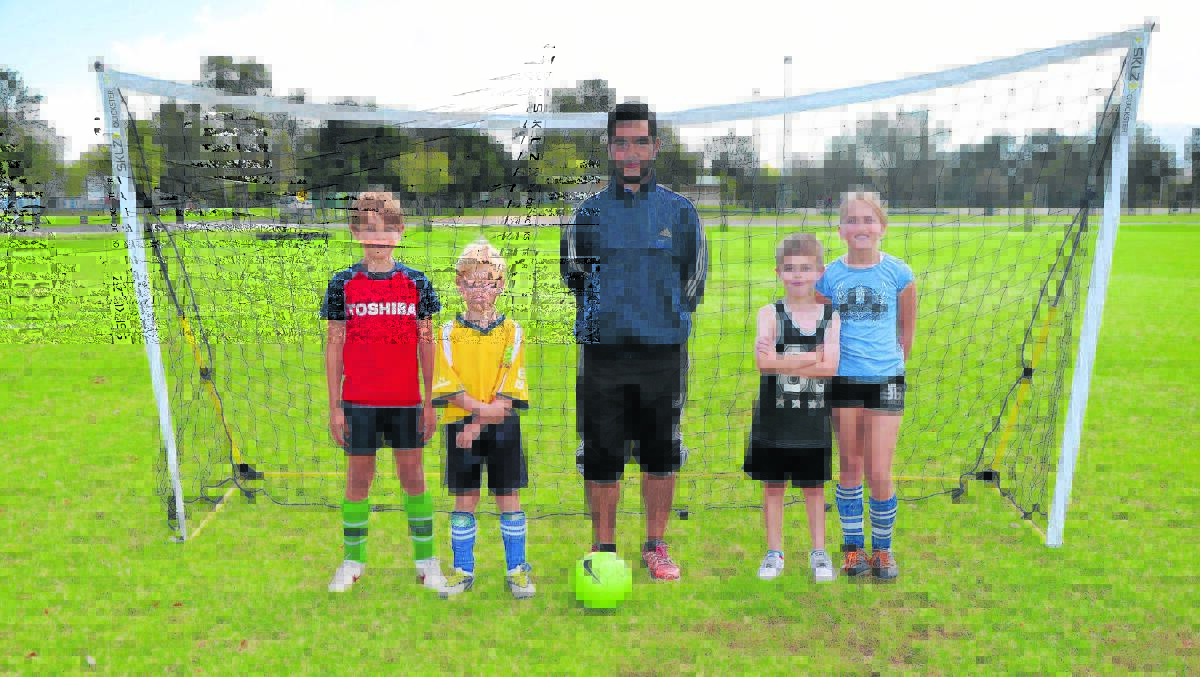 Local youngsters Roly Ward-Thomas, Monty Ward-Thomas, NSW Football Academy representative Reece Fellas, Jesse Blayden and Anekah Bettens ready to learn some new soccer skills on Monday.