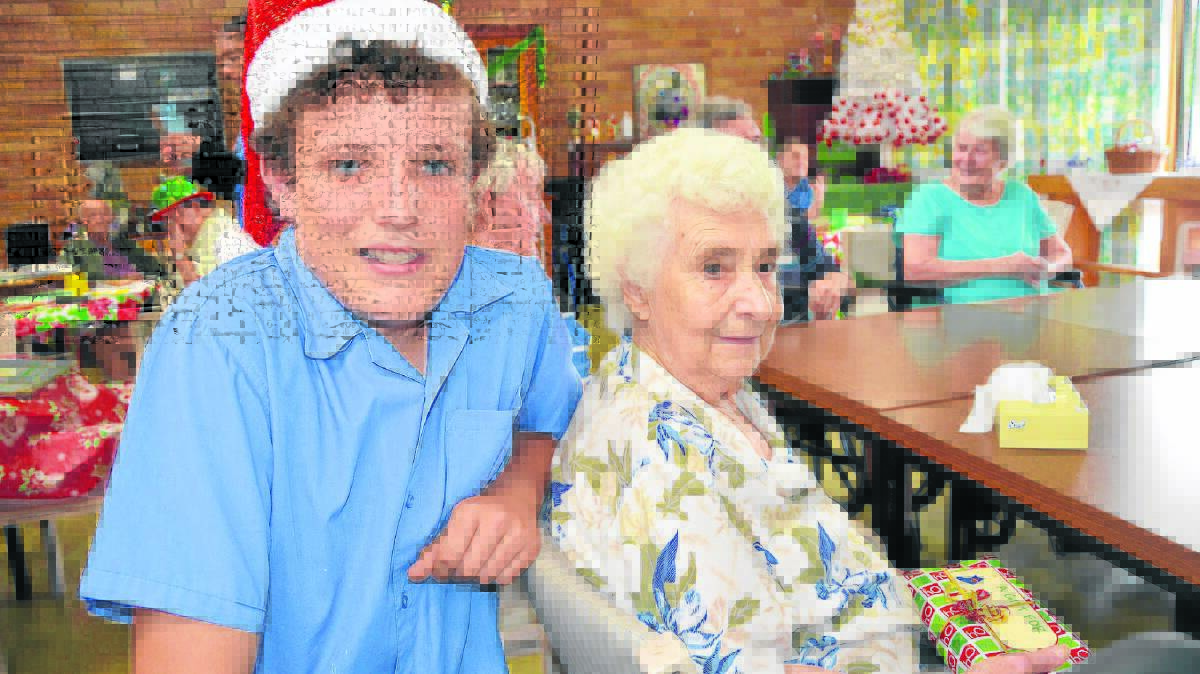 Scone High School Student Representative Council president Jake Speck gives Strathearn resident Olga Mason her Christmas present from the school community.