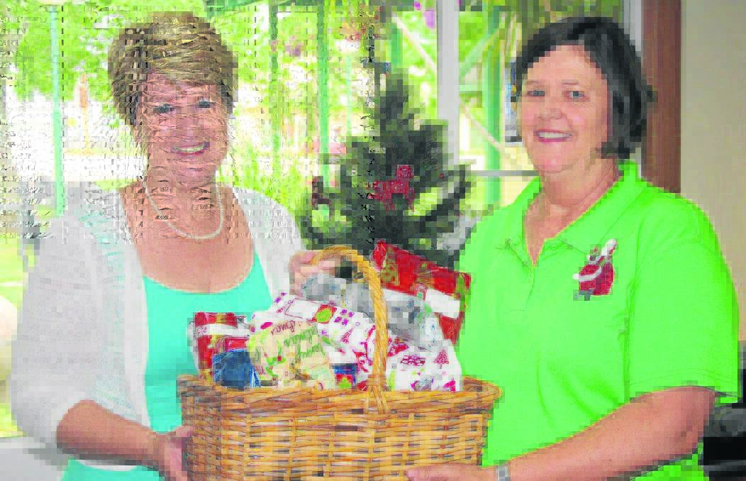 Scone Neighbourhood Centre manager Lee Watts presents Strathearn Director of Care Janelle Birch with the gifts given by the  community to the Gift Giving Tree.