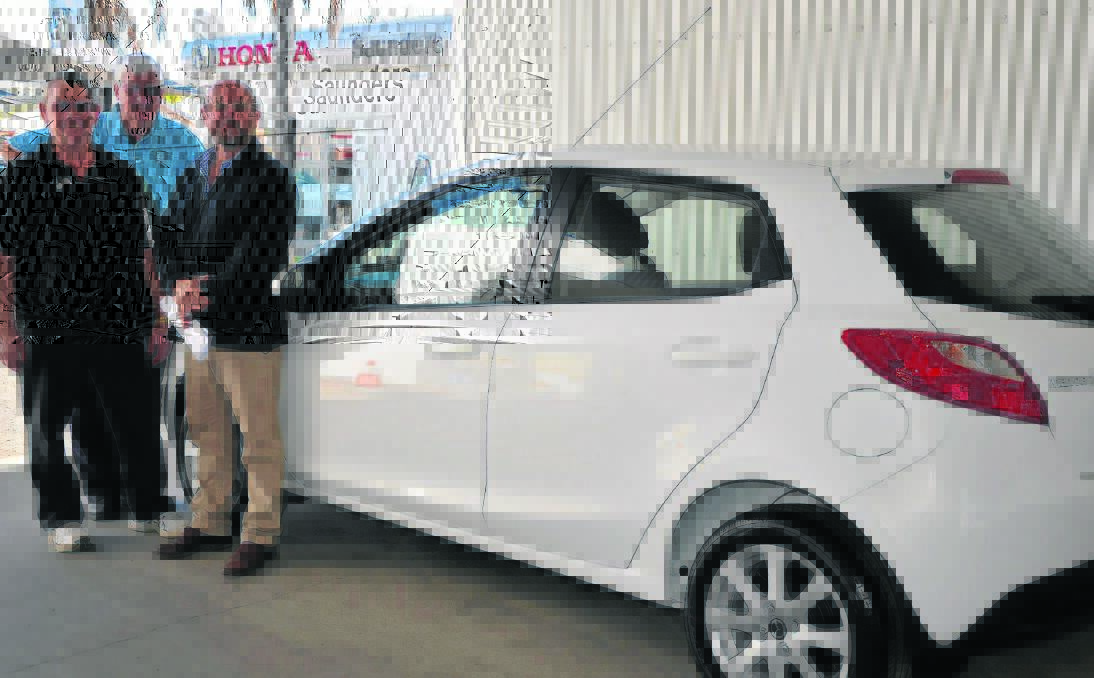 Scone Golf Club representative Phil McGuirk (back), president Paul Smart and Saunders Motor Group dealer principal Darren Saunders with the brand new fully registered Mazda 2 automatic car to be won on the 17th hole of the 2014 Scone Open. 