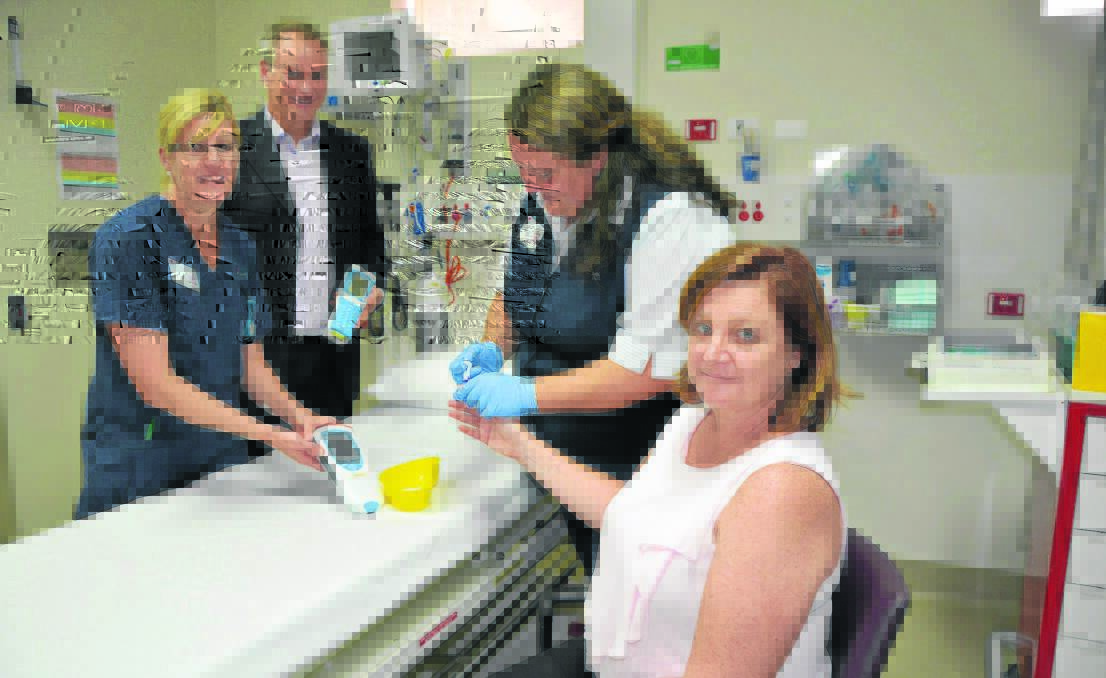 Scott Memorial Hospital emergency department registered nurse Suzanne Pollard, NSW Health Pathology project manager Andrew Sargeant with Scott Memorial Hospital emergency department acting nurse unit manager Chrissy Haddrill testing the device on Peta Cooper.