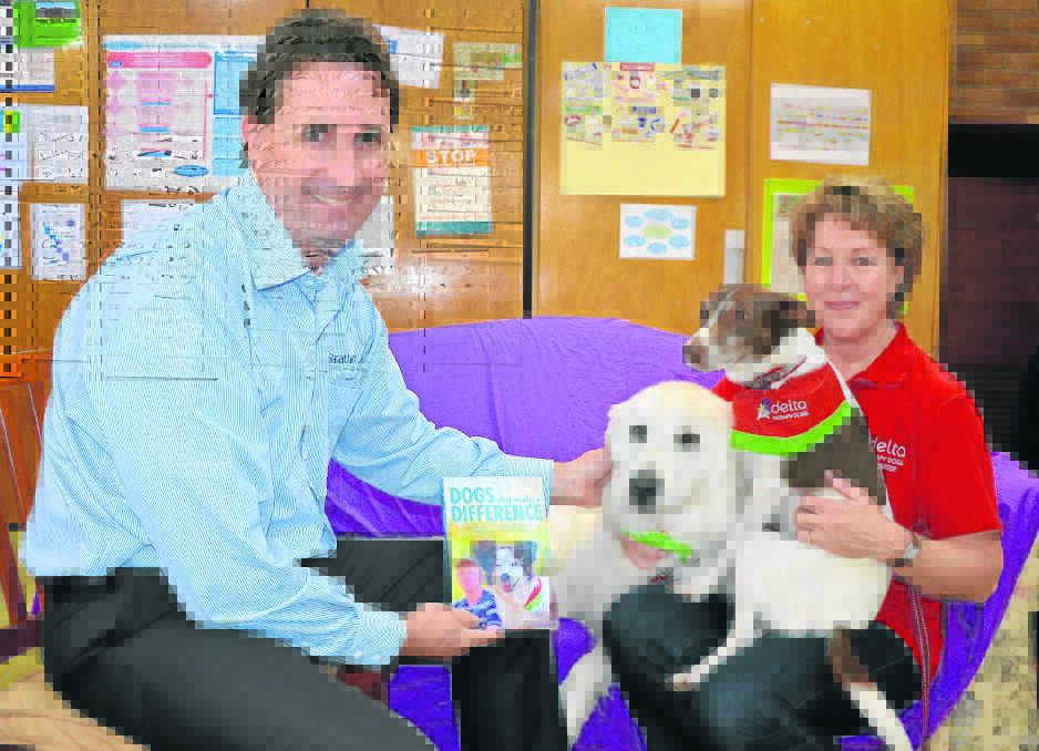 Strathearn chief executive officer Matthew Downie with the local Delta Therapy Dog team of Erin Williams, ‘Fifi’ and ‘Roberto’ and the new book ‘Dogs That Make A Difference’.