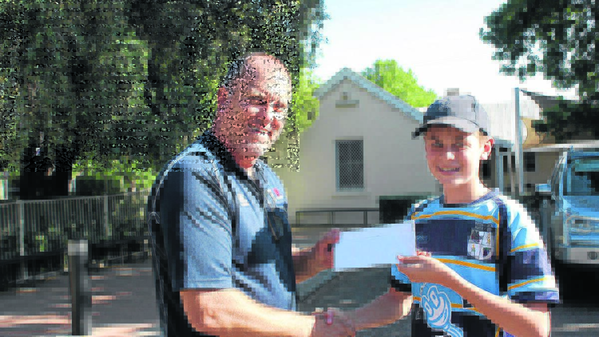 NSW Rugby North West participation manager Garry Walsh presents Scone Junior Rugby Union player Tully O’Regan with his scholarship to the New England Community Mutual National Rugby Camp.