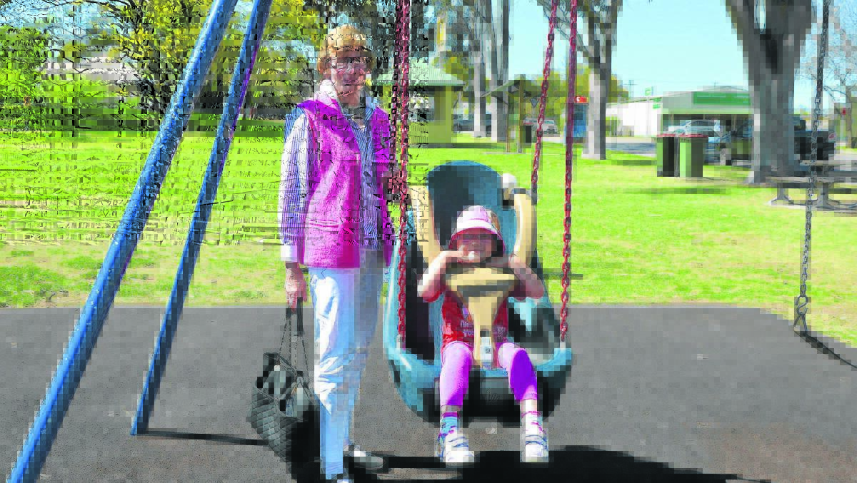 Scone and Murrurundi community volunteer Jan Hollow with little Madeleine Wesble on one of the swings the Rotary Club of Scone fund raised for. 