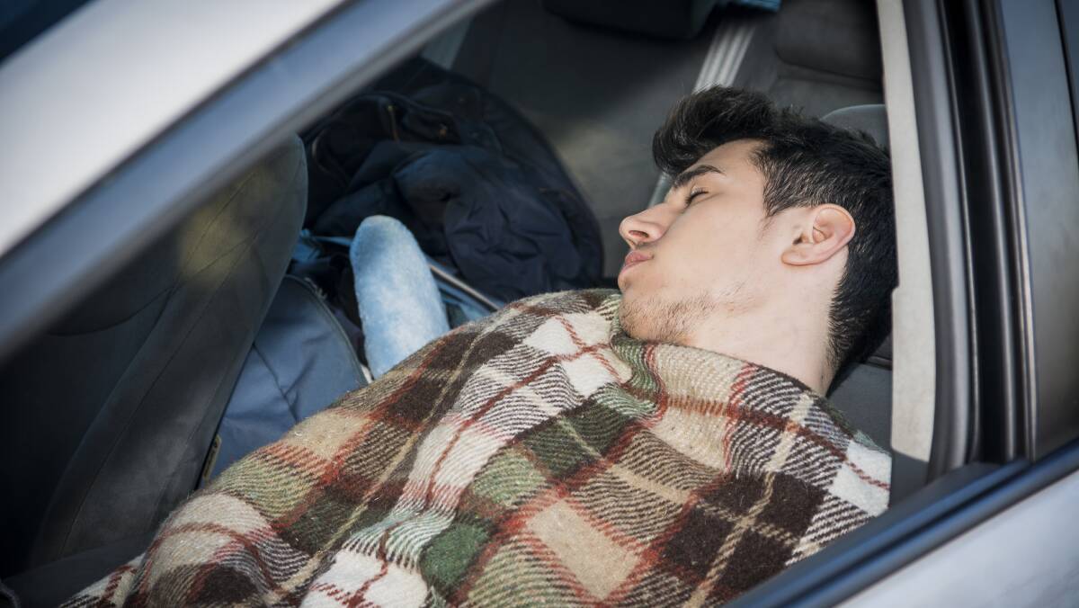 A young man sleeps in a car. Picture by Dan Peled / AAP