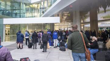 People wait outside of Canberra Airport after a man fired a gun inside the terminal. Picture: Keegan Carroll