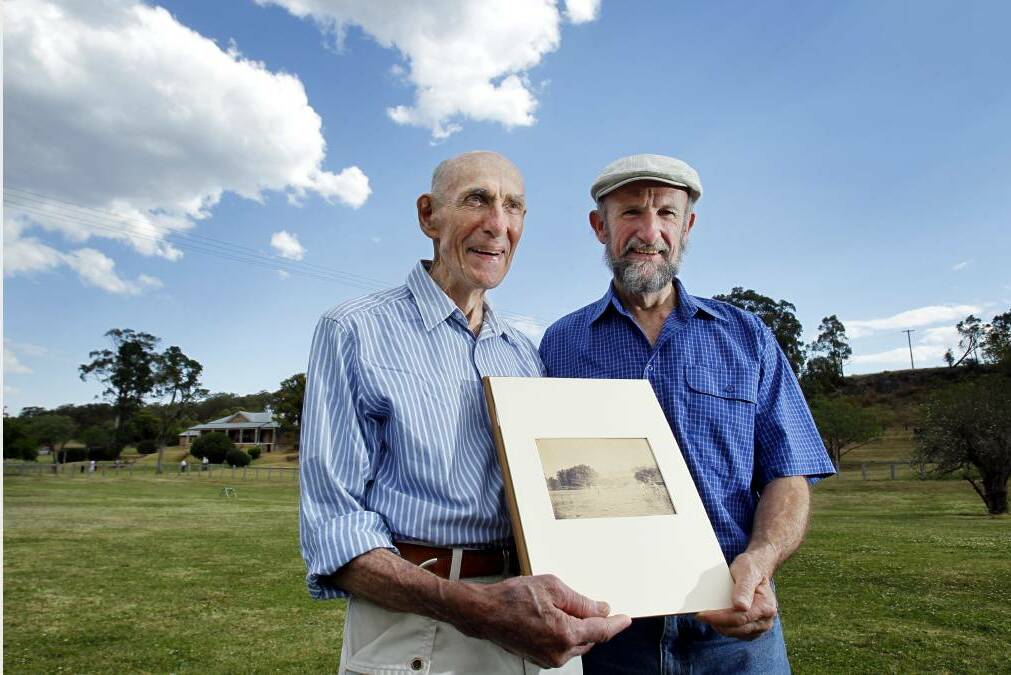 Peter Docker and his son Geoffry with the original photograph by Peter's great-grandfather Joseph Docker, which is thought to be the first photograph of a game of cricket. Picture: Max Mason-Hubers