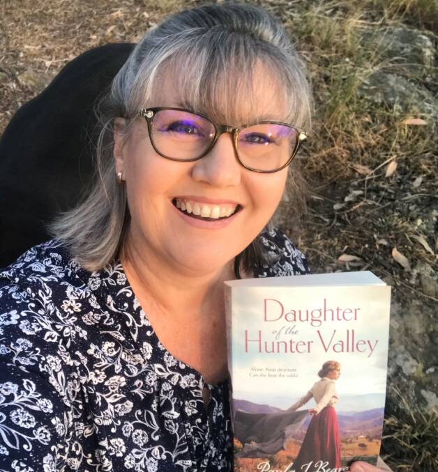 Paula Beavan with a copy of her debut novel, Daughter of the Hunter Valley
