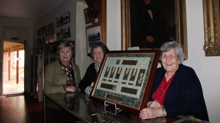 TALKING GRANTS: Upper Hunter Shire Council’s community grants officer Jacqui Bakewell with Scone and Upper Hunter Historical Society Inc. curator Margaret MacDougall and president Janice Cameron with historic military medals from the Cobbs collection at the Museum in Kingdon Street. The Historical Society has successfully worked with council to receive grants for the Museum.
