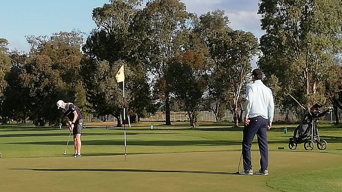 Adam Brayshaw finishes his round, as Andrew Parry-Okeden looks on, at the 18th hole on June 27