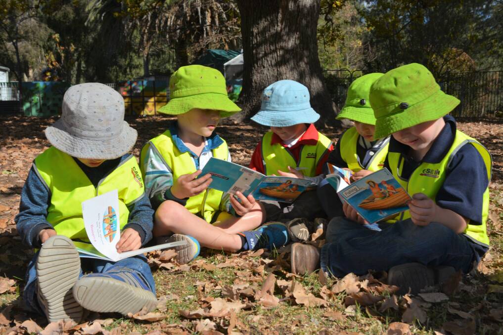 HEADS DOWN: Murrurundi Preschool students Xander, Max, Hunter, Zachariah and Judd enjoy their books in the sun.