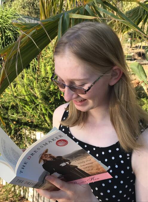 GET CREATIVE: Last year's competition winner Kaitland Parker reading a copy of The Dressmaker by Rosalie Ham.