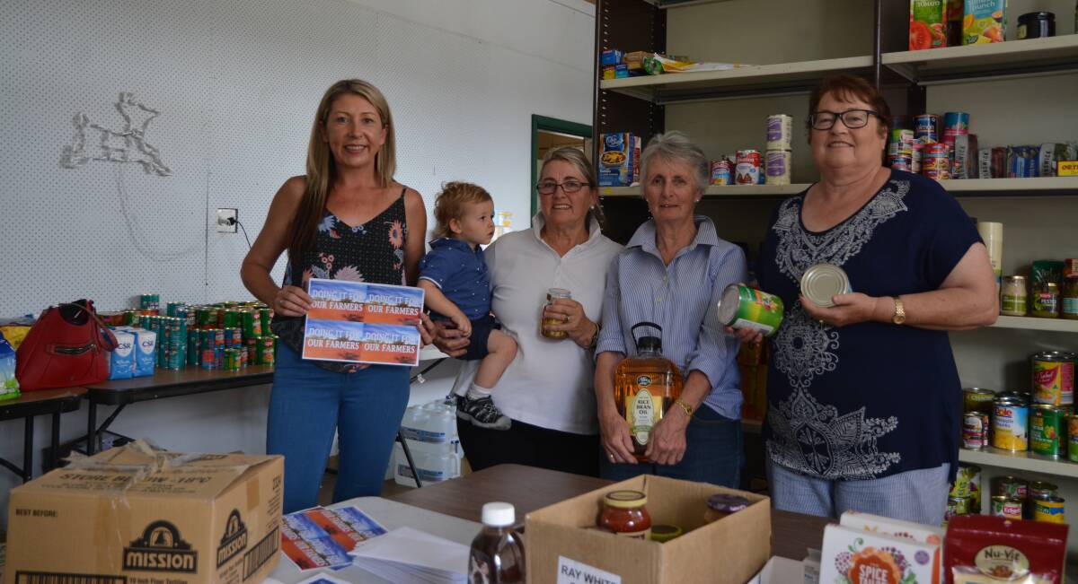BAND OF HELPERS: Justine Cooper with Christine Betts and Isaac Cooper, Jenny Loasby and Rhonda Firth at their Pop-Up Pantry on Mayne Street. They are just some of the volunteers who have put in countless hours of work.