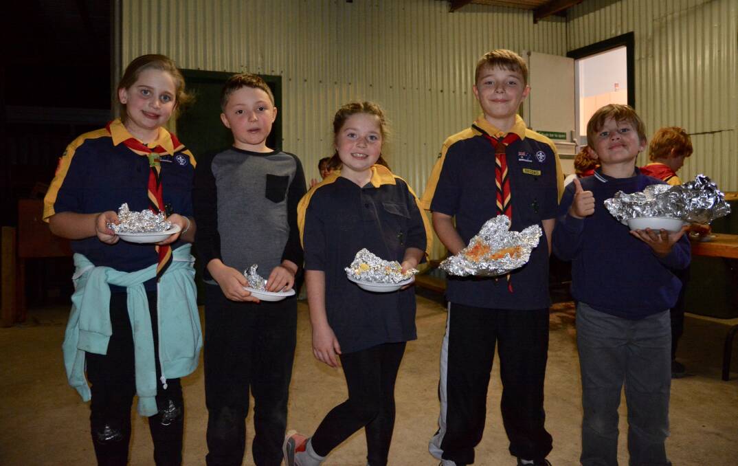 SOCIAL TIME: Mollie, James, Jasmine, Toby and Darcy enjoying their dinner that they cooked under the campfire at Cubs meeting on Monday night. 