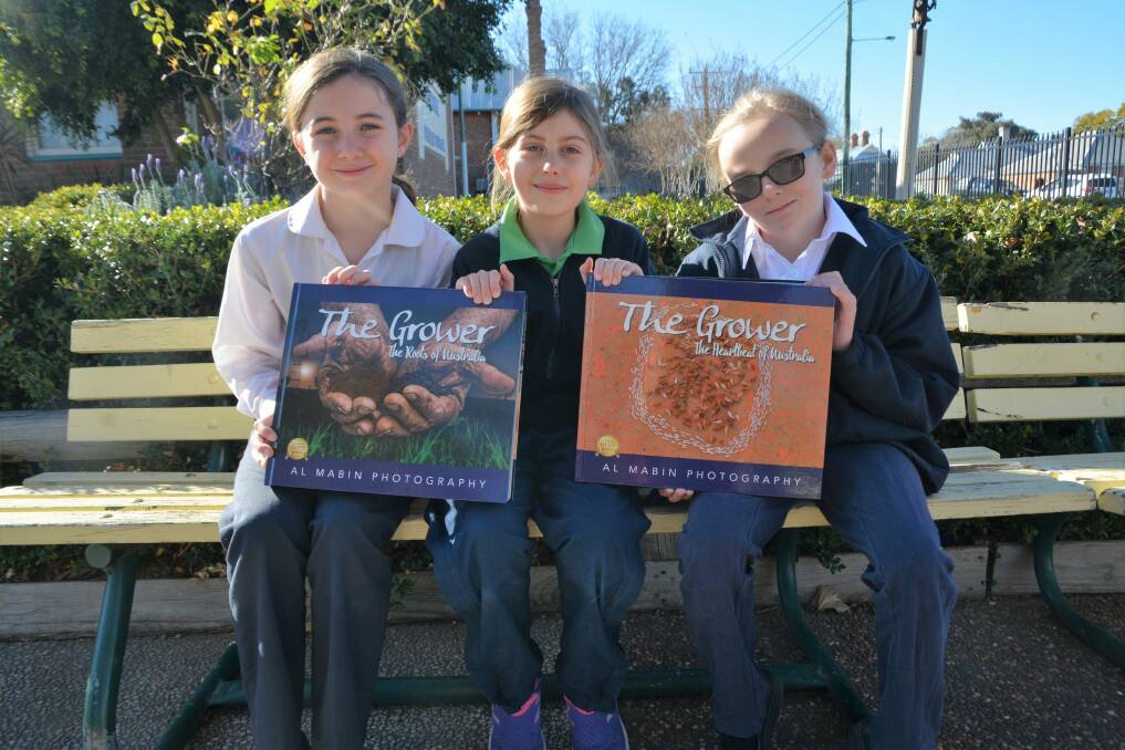 ROOTS OF AUSTRALIA: Scone Public School students Phoebe, Alexia and Carolyn with the copy of Alice Mabin's The Grower series which was donated to local schools this week. 