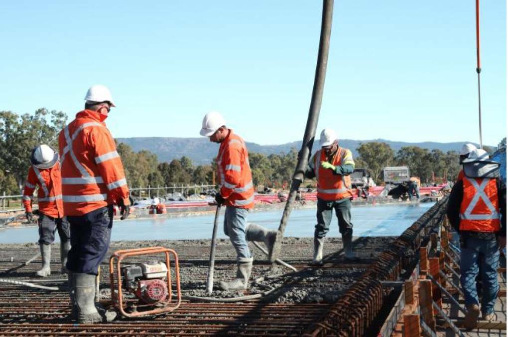 Workers placing concrete on the rail bridge deck during construction of the Scone Bypass. Photo: RMS