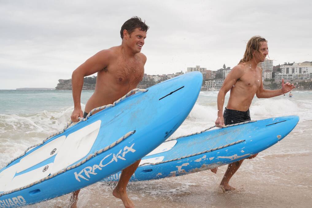 Action men: Bondi Rescue lifeguards Harrison and Jethro motor up the beach during training. Photo supplied