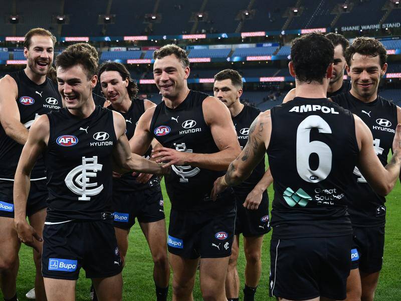 Carlton Blues players celebrate a victorious end to a difficult week with their win over the Tigers. Photo: Joel Carrett/AAP PHOTOS