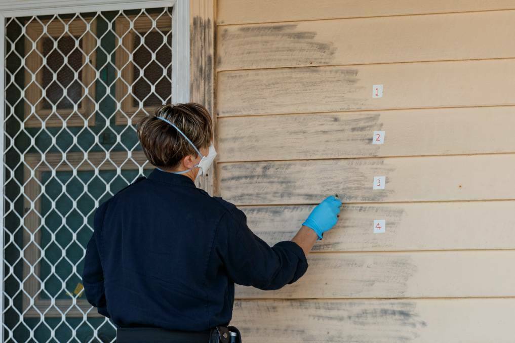 Specialist police examining the crime scene at the front door of a home at Stockton where Stacey Klimovitch was shot and killed in June, 2021. Picture by Max Mason-Hubers
